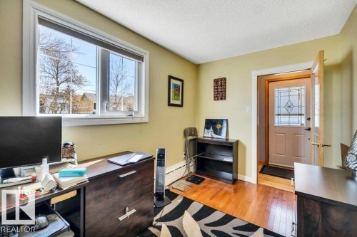 Room featuring wood-finish flooring and a large window with white trim - 10616 136 Street, Edmonton, AB - Indoor Photo Showing Office