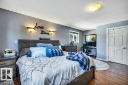 Spacious room featuring wood-finish flooring, a paneled door, and a window for natural light - 