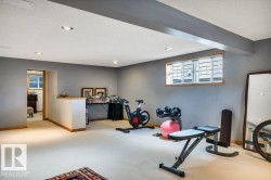 Finished lower level featuring recessed lighting, a wood-trimmed egress window, broadloom carpeting, and a half-wall with a wood-finish cap - 
