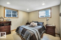 Bedroom featuring two windows with wood-finish trim, recessed ceiling lighting, and carpet flooring - 