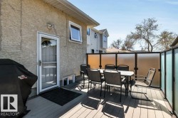 Outdoor deck with composite plank flooring, a frosted panel privacy screen, and direct access to the interior via a full-view storm door - 