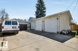 Two-car detached garage with stucco exterior and white garage doors - 