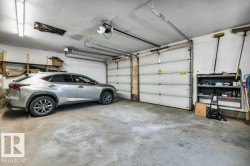Two-car garage featuring concrete flooring, segmented garage doors, and overhead track lighting - 