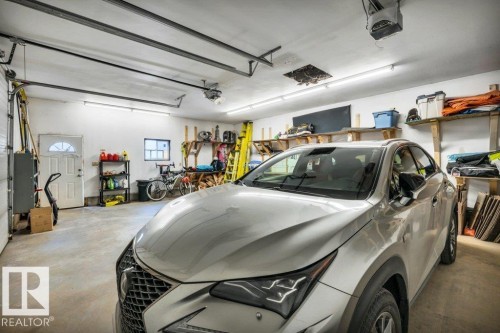 Spacious two-car garage featuring a concrete floor, white painted walls, and overhead fluorescent lighting - 10616 136 Street, Edmonton, AB - Indoor Photo Showing Garage