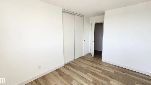Neutral wall tones complement wood-finish flooring - 603 9028 Jasper Avenue, Edmonton, AB - Indoor Photo Showing Other Room