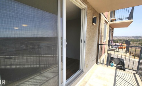 Private balcony with concrete flooring and black metal railings, featuring an exterior wall sconce - 603 9028 Jasper Avenue, Edmonton, AB - Outdoor With Exterior
