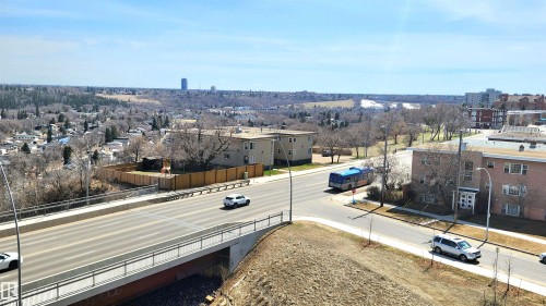 Expansive urban landscape featuring a multi-lane roadway, established neighborhood structures, and distant natural terrain - 603 9028 Jasper Avenue, Edmonton, AB - Outdoor With View