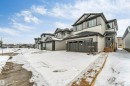The property features a two-story exterior with light-colored siding and dark grey accents - 97 Dansereau Way, Beaumont, AB  - Outdoor 