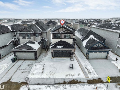 The property features a two-story home with a two-car garage and a paved driveway - 97 Dansereau Way, Beaumont, AB - Outdoor With Facade