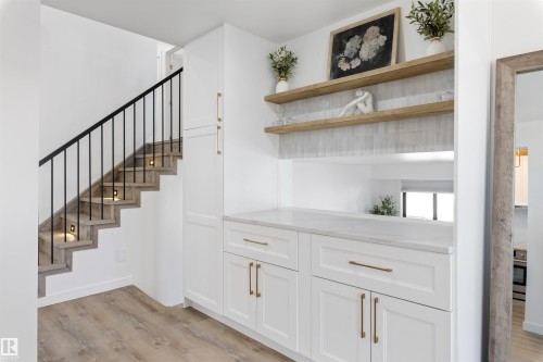 Modern staircase with integrated lighting and black metal balusters - 38 Woodcrest Avenue, St. Albert, AB - Indoor Photo Showing Other Room