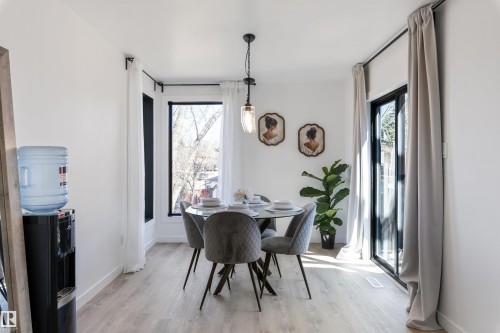 Dining area with light wood-finish flooring, white walls, and a modern pendant light fixture - 38 Woodcrest Avenue, St. Albert, AB - Indoor Photo Showing Dining Room