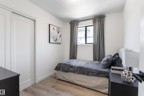 Bedroom featuring wood-finish flooring, a window with dark curtain rods, and white walls - 38 Woodcrest Avenue, St. Albert, AB - Indoor Photo Showing Bedroom