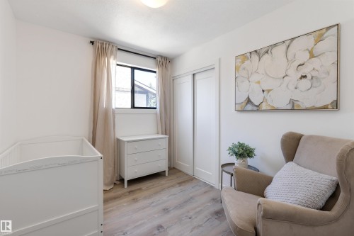 Bright room featuring a window with natural light, wood-finish flooring, a ceiling-mounted light fixture, and a closet with sliding doors - 38 Woodcrest Avenue, St. Albert, AB - Indoor