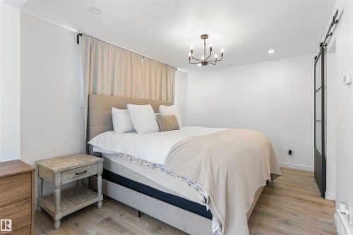 Bright bedroom featuring light wood-finish flooring and white walls - 38 Woodcrest Avenue, St. Albert, AB - Indoor Photo Showing Bedroom