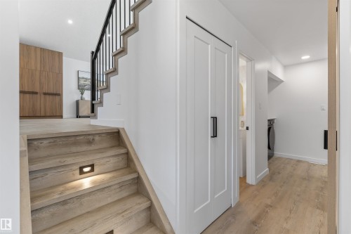 Wood-finish staircase with integrated step lighting and black metal balusters - 38 Woodcrest Avenue, St. Albert, AB - Indoor Photo Showing Other Room
