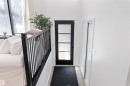 Entryway featuring a contemporary black door with multiple clear glass panels, light wood-finish flooring, and white walls - 38 Woodcrest Avenue, St. Albert, AB  - Indoor Photo Showing Other Room 