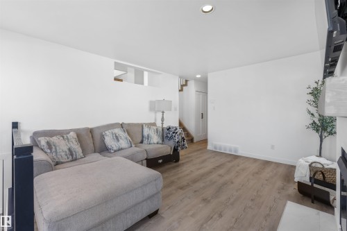 Spacious living area featuring wood-finish flooring, recessed lighting, and a white color palette - 38 Woodcrest Avenue, St. Albert, AB - Indoor Photo Showing Living Room