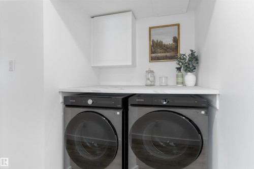 Dedicated laundry area featuring a white countertop with a subtle marble-look finish, overhead white cabinetry, and front-loading appliances - 38 Woodcrest Avenue, St. Albert, AB - Indoor Photo Showing Laundry Room