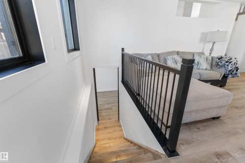 Modern stairwell with black metal railing, wood-finish treads, and white risers - 38 Woodcrest Avenue, St. Albert, AB -  Photo Showing Other Room