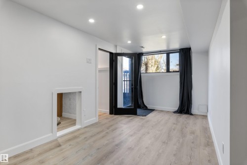 Finished lower-level space featuring light wood-finish flooring, recessed ceiling lighting, and a window with black trim - 38 Woodcrest Avenue, St. Albert, AB - Indoor Photo Showing Other Room