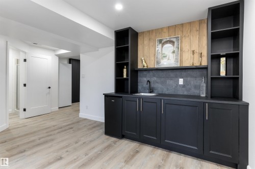 Custom built-in wet bar featuring dark cabinetry, integrated sink, and black countertop - 38 Woodcrest Avenue, St. Albert, AB - Indoor Photo Showing Other Room