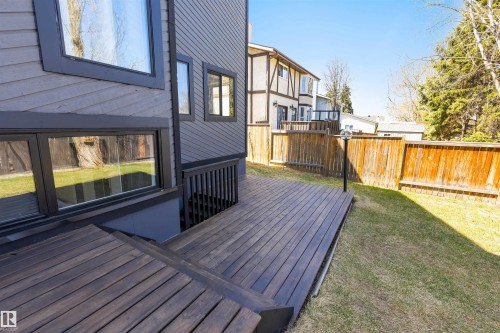 Expansive wooden deck with coordinating steps, surrounded by a manicured lawn and privacy fencing - 38 Woodcrest Avenue, St. Albert, AB - Outdoor With Deck Patio Veranda With Exterior