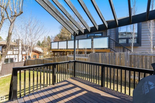 Expansive multi-level wood-finish deck with a pergola, black metal railings, and a lower-level grass area - 38 Woodcrest Avenue, St. Albert, AB - Outdoor With Deck Patio Veranda With Exterior