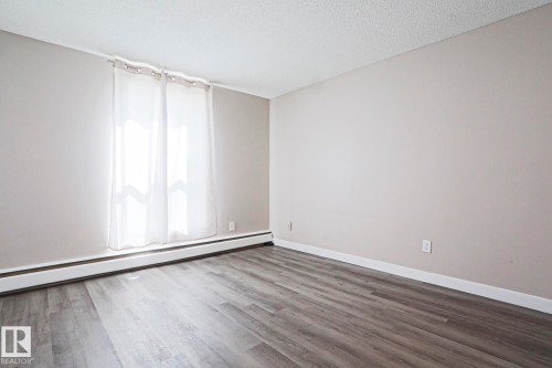 Interior space featuring light grey painted walls and wood-finish flooring - 118 7220 144 Avenue, Edmonton, AB - Indoor Photo Showing Other Room