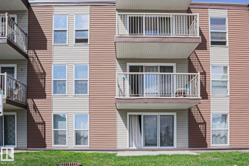 Multi-level building exterior featuring two-tone vinyl siding in brown and beige - 118 7220 144 Avenue, Edmonton, AB - Outdoor With Exterior