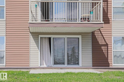 Ground-floor patio with direct access to a grassy area, featuring a sliding glass door entry - 118 7220 144 Avenue, Edmonton, AB - Outdoor With Exterior
