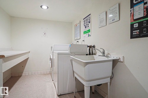 Dedicated laundry area featuring white wall paint, recessed ceiling lighting, a utility sink with a chrome faucet, and white square tile flooring - 118 7220 144 Avenue, Edmonton, AB - Indoor Photo Showing Laundry Room