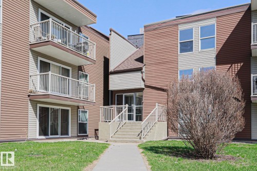 Multi-level building exterior featuring brown and light-colored siding, multiple balconies with white railings, and sliding glass doors - 118 7220 144 Avenue, Edmonton, AB - Outdoor