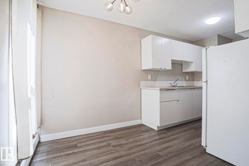 Kitchenette featuring white cabinetry, a single basin sink, and laminate countertops - 118 7220 144 Avenue, Edmonton, AB - Indoor Photo Showing Kitchen
