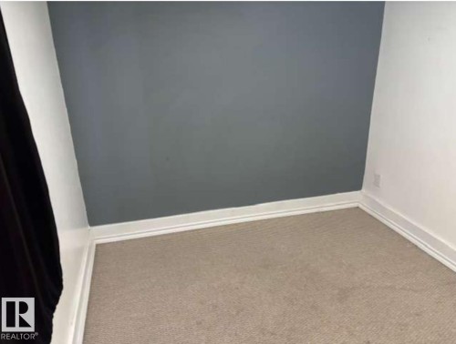 Room featuring a neutral carpet, white baseboards, and a contrasting accent wall - 10730 92 Street, Edmonton, AB - Indoor Photo Showing Other Room