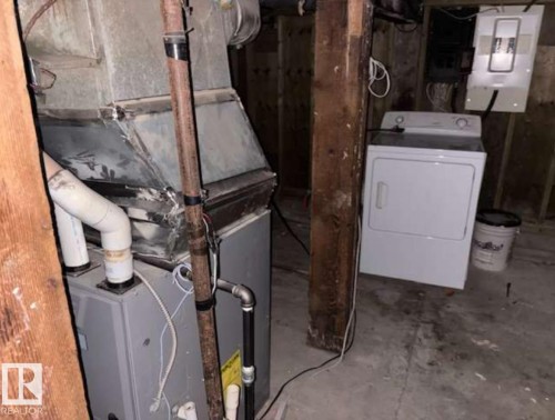 Utility area featuring a furnace system, exposed ductwork, and a clothes dryer - 10730 92 Street, Edmonton, AB - Indoor Photo Showing Laundry Room