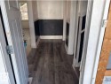 Hallway featuring wood-finish flooring, wainscoting with a herringbone pattern, white trim, and a white interior door - 10730 92 Street, Edmonton, AB  - Indoor 