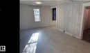 Spacious room featuring light-toned wood-finish flooring, white painted walls, and a prominent shiplap accent wall - 10730 92 Street, Edmonton, AB  - Indoor Photo Showing Other Room 