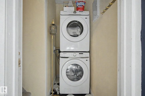 Dedicated laundry area featuring stacked front-loading appliances - 11512 122 St, Edmonton, AB - Indoor Photo Showing Laundry Room