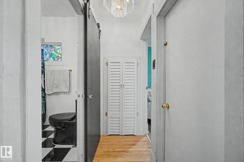 Hallway featuring wood-finish flooring and a crystal chandelier - 11512 122 St, Edmonton, AB - Indoor Photo Showing Other Room