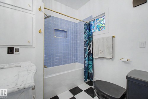 Bathroom featuring a built-in tub with light blue subway tile surround and integrated niche - 11512 122 St, Edmonton, AB - Indoor Photo Showing Bathroom