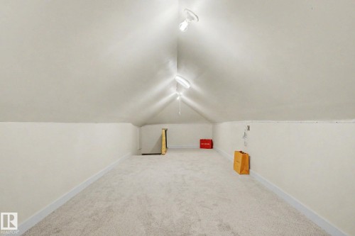 Finished attic space featuring vaulted ceilings, track lighting, and light-colored carpeting - 11512 122 St, Edmonton, AB - Indoor Photo Showing Other Room