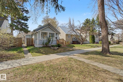 Light blue siding on the primary structure, featuring a covered porch with white trim and a gabled roof - 11512 122 St, Edmonton, AB - Outdoor With Facade