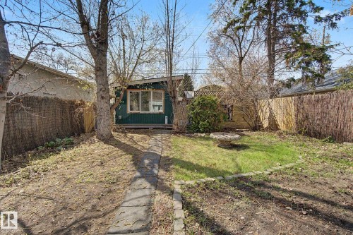 Rear property with a standalone structure featuring horizontal siding and multiple windows - 11512 122 St, Edmonton, AB - Outdoor