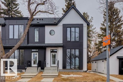 Modern townhome exterior featuring a striking black and white facade, large windows with dark frames, a prominent gabled roofline, and a circular accent window - 14816 93 Avenue, Edmonton, AB - Outdoor With Facade