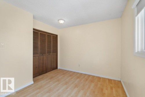 This room features light-colored walls, light wood-style flooring, and a window with vertical blinds - 17313 60 Avenue, Edmonton, AB - Indoor Photo Showing Other Room