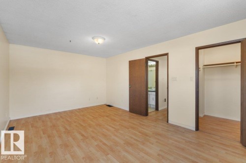 This spacious room features light wood-look flooring and neutral-toned walls - 17313 60 Avenue, Edmonton, AB - Indoor Photo Showing Other Room