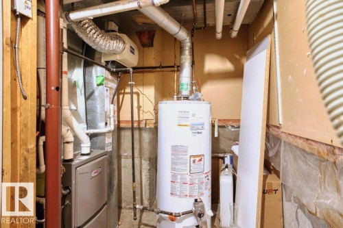The property features a water heater and a furnace, demonstrating essential utilities - 17313 60 Avenue, Edmonton, AB - Indoor Photo Showing Basement