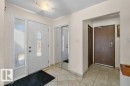 Entrance featuring tiled flooring, a white main entry door with decorative glass, and a mirrored closet door - 17313 60 Avenue, Edmonton, AB  - Indoor Photo Showing Other Room 