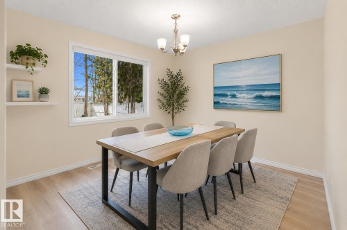 Dining area with wood-finish flooring and a contemporary chandelier - 17313 60 Avenue, Edmonton, AB - Indoor Photo Showing Dining Room