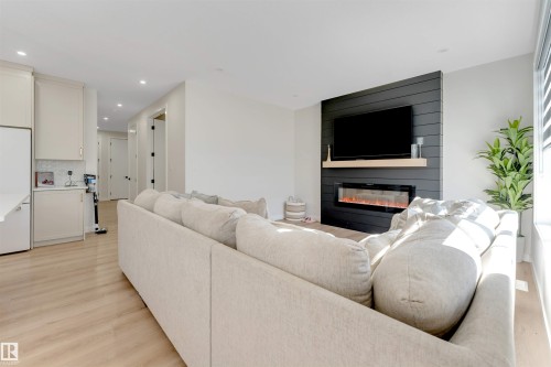 Living area featuring light wood-finish flooring and recessed lighting - 7007 169 Avenue Nw, Edmonton, AB - Indoor Photo Showing Living Room With Fireplace